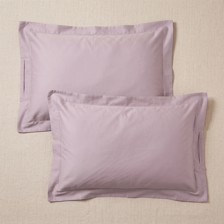Cotton Sateen Pillowcases – Set of 2 in Mauve – unfolded pillowcases overlapping, showing side slit openings, on woven surface