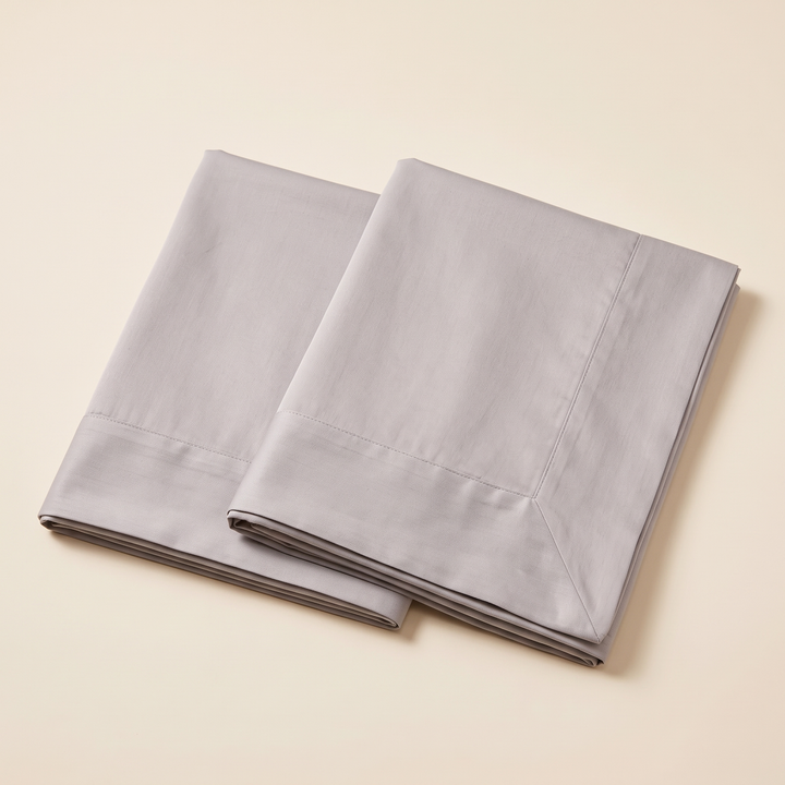 Cotton Sateen Pillowcases – Set of 2 in Gray – two folded pillowcases stacked on a cream background