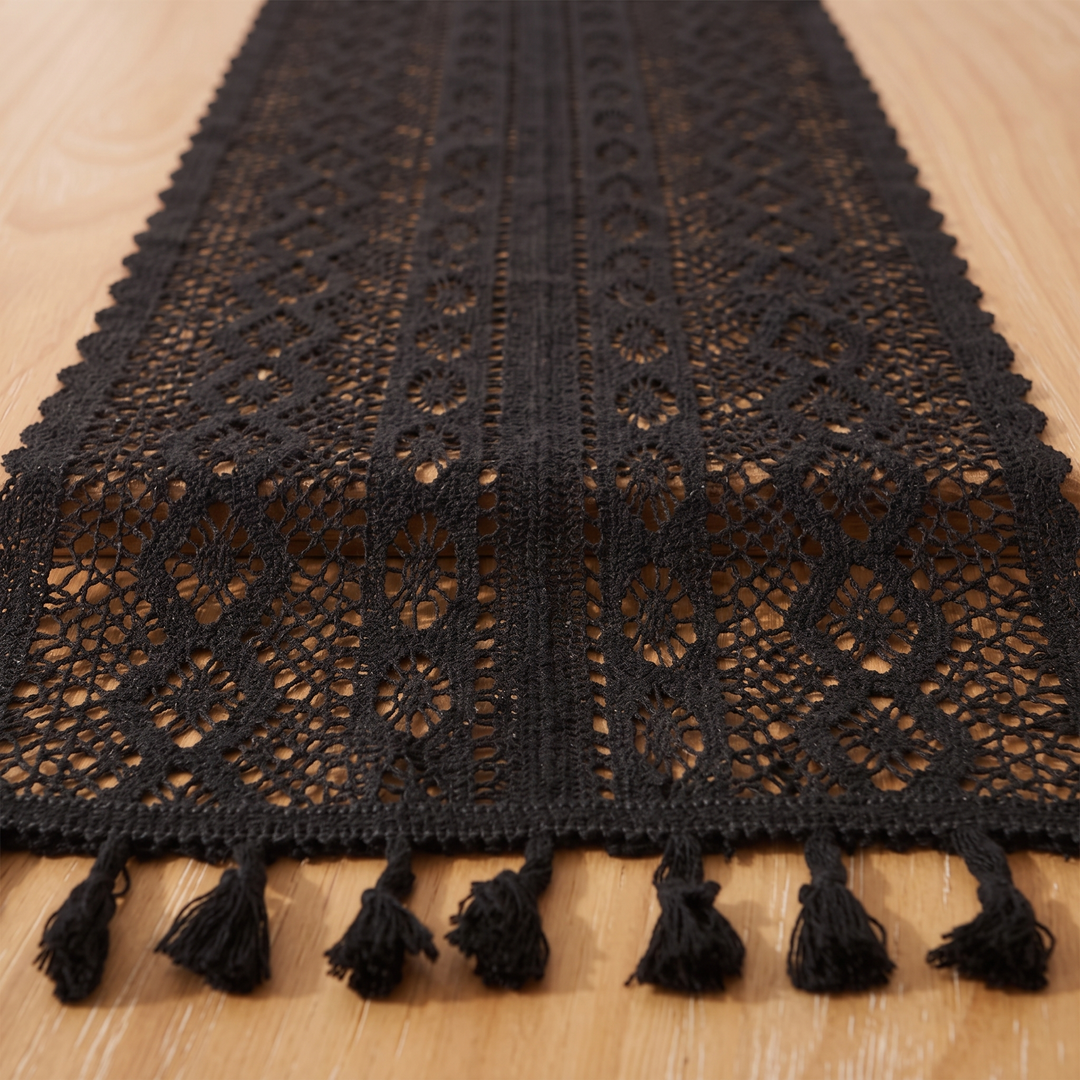 Crochet Table Runner in Black – Tasseled Ends – end of runner with tassels laid flat on light wood