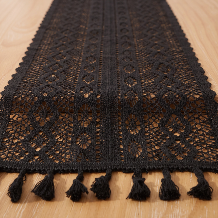 Crochet Table Runner in Black – Tasseled Ends – end of runner with tassels laid flat on light wood