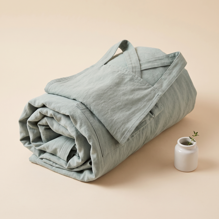 Cotton-Linen Cross-Back Apron in Mint Green – rolled into a bundle with cross straps resting on top