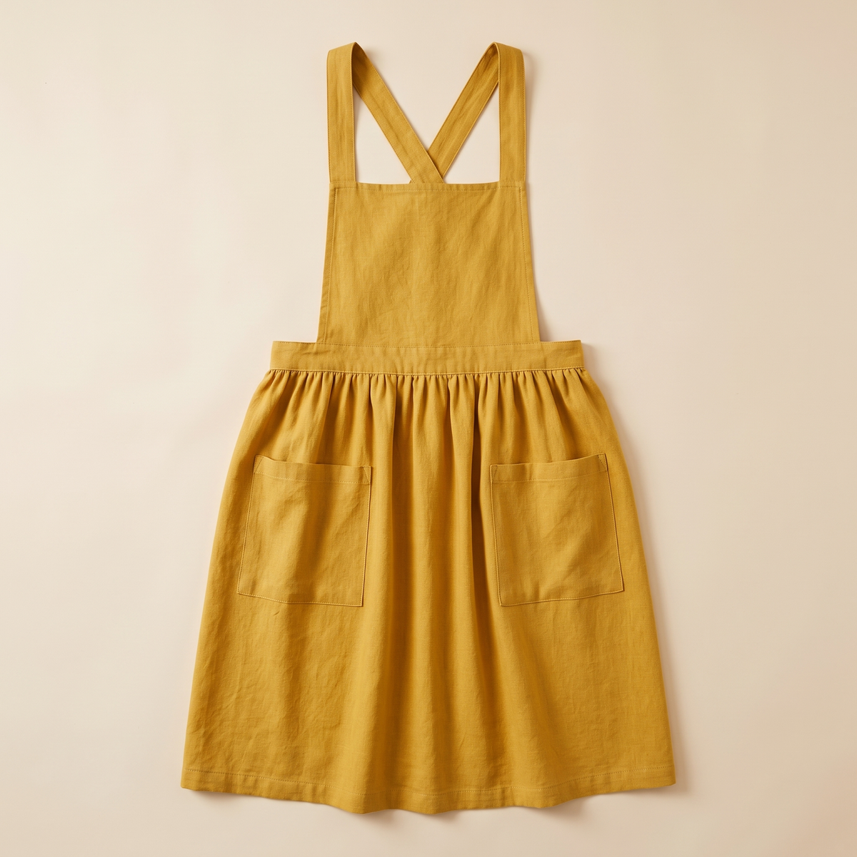Cotton-Linen Cross-Back Apron in Yellow – laid flat, front view, on a plain cream background