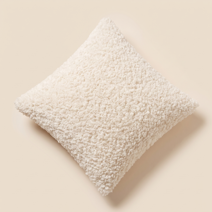 Curly Faux Fur Pillow Cover in Cream – set on its corner, viewed from above, casting soft shadow