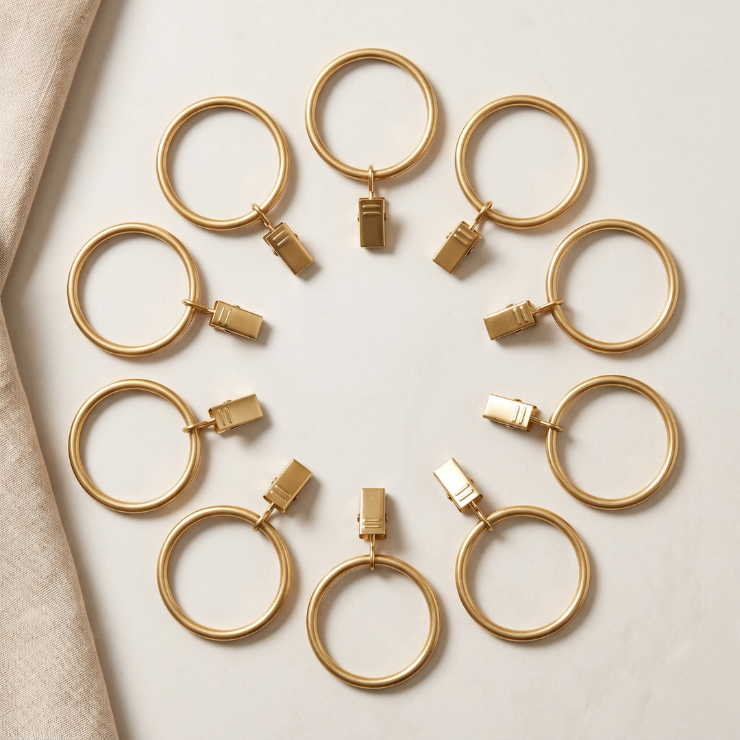 Metal Curtain Rings with Clips in Gold – ten rings with clips arranged in a circle beside linen fabric