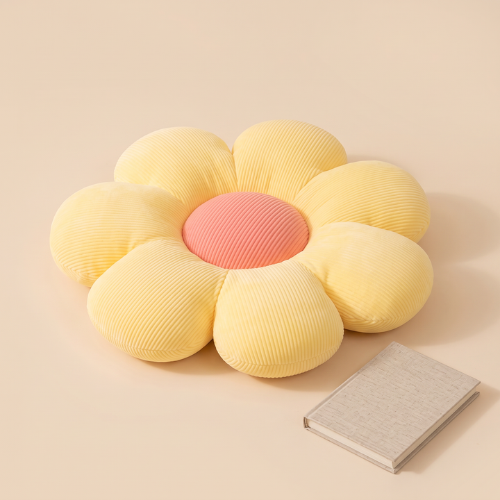 Daisy Flower Pillow in Light Yellow – lying flat beside a closed linen-covered notebook
