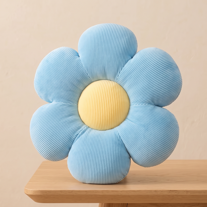 Daisy Flower Pillow in Light Blue – perched on the edge of a light wood table
