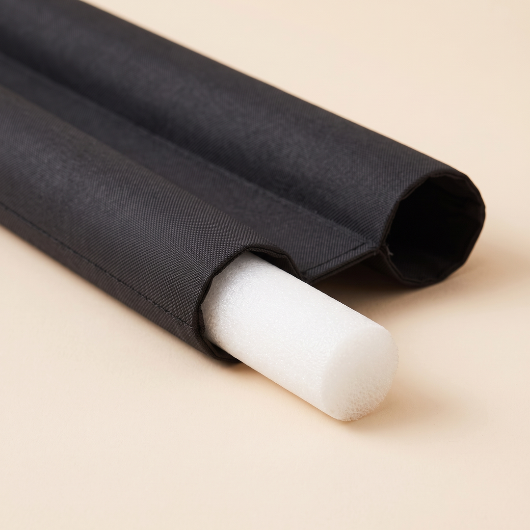 Door Draft Stopper – Twin Tube, Under-Door in Black – close-up of white foam insert sliding out of fabric tube end