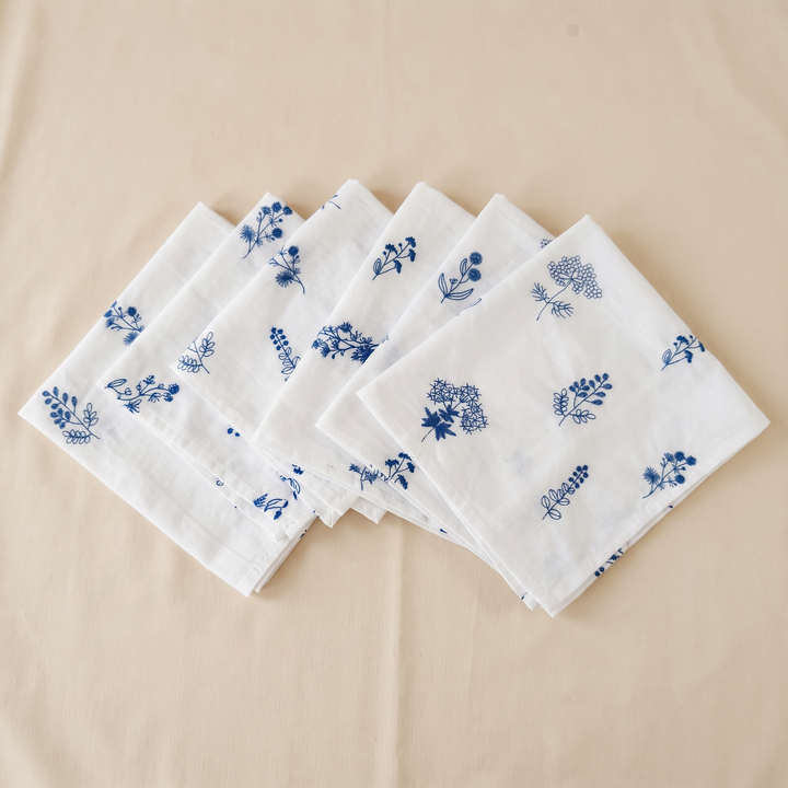 Embroidered Cotton Napkins – Set of 6 in White – Botanical – six folded napkins fanned out on a cream fabric surface