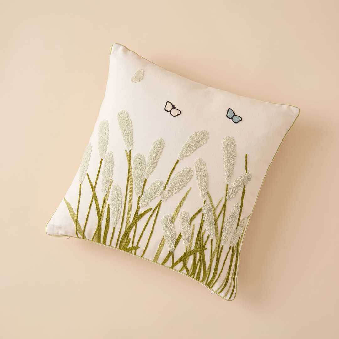 Embroidered Botanical Pillow Cover in Cream – Sage Reed Grass – flat lay from above, set diagonally on a plain peach surface