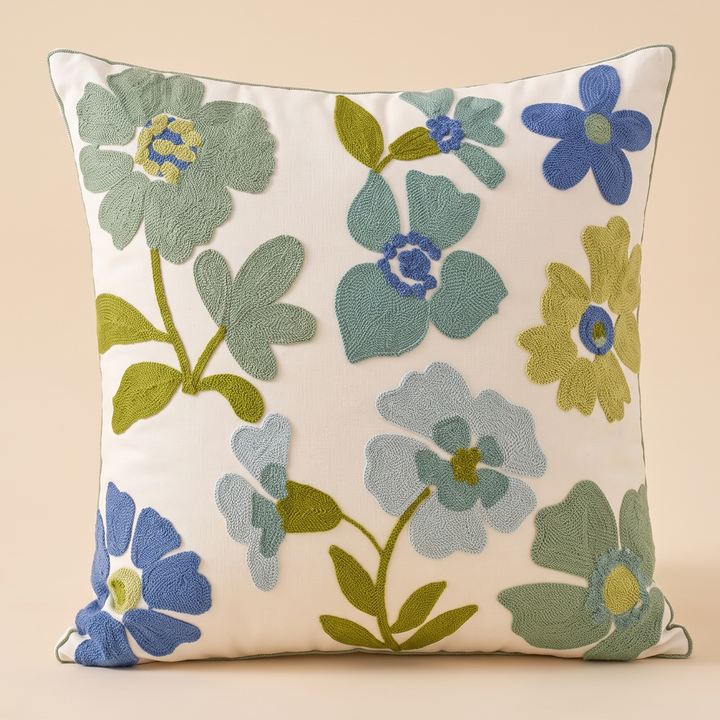 Embroidered Botanical Pillow Cover in Cream – Blue Floral – front view standing upright against a plain peach background