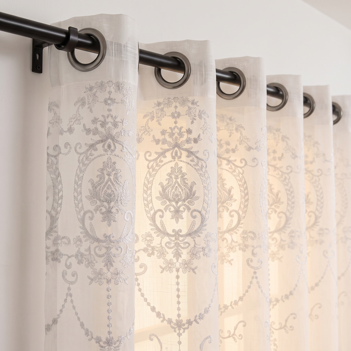 Embroidered Sheer Curtain Panel – Grommet Top in White – close-up of grommet tops and damask embroidery on black rod