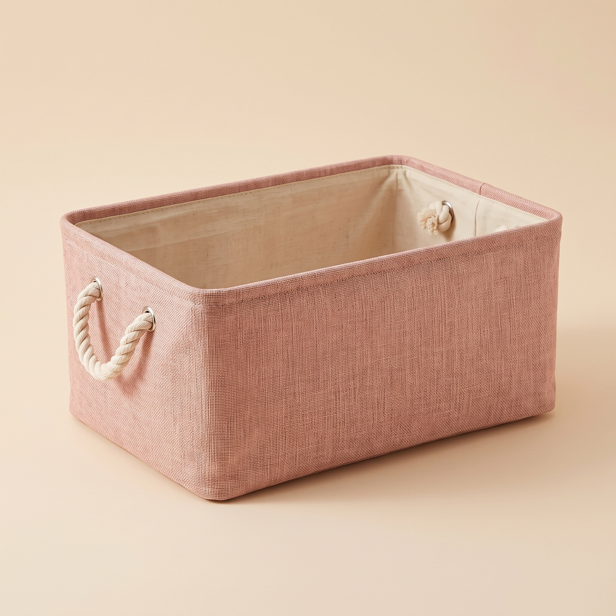 Foldable Fabric Storage Bin with Handles in Dusty Pink – empty, shown at an angle against a plain beige backdrop