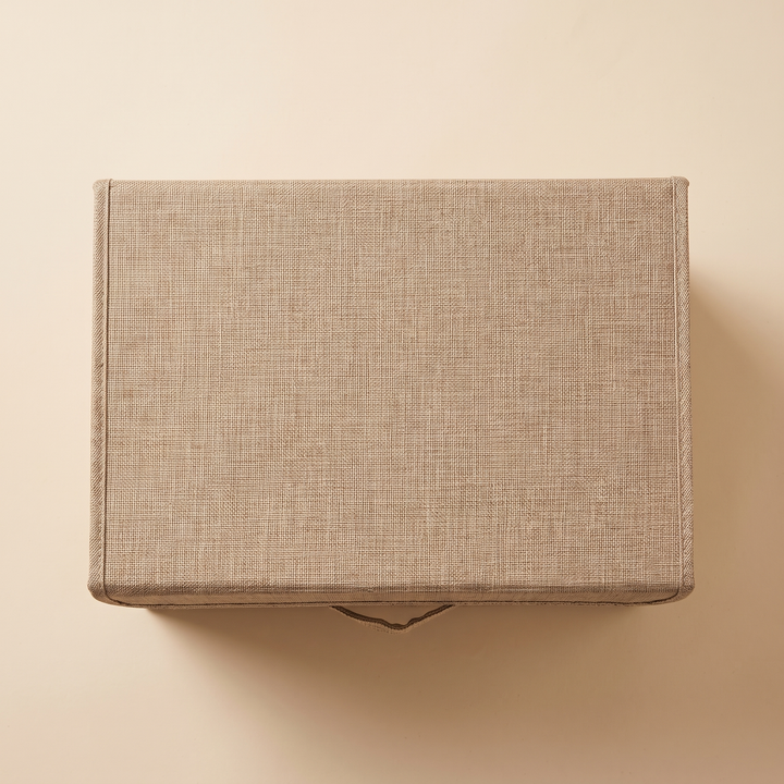 Fabric Storage Bin with Lid – Foldable in Beige – overhead top-down view of closed lid on plain peach background