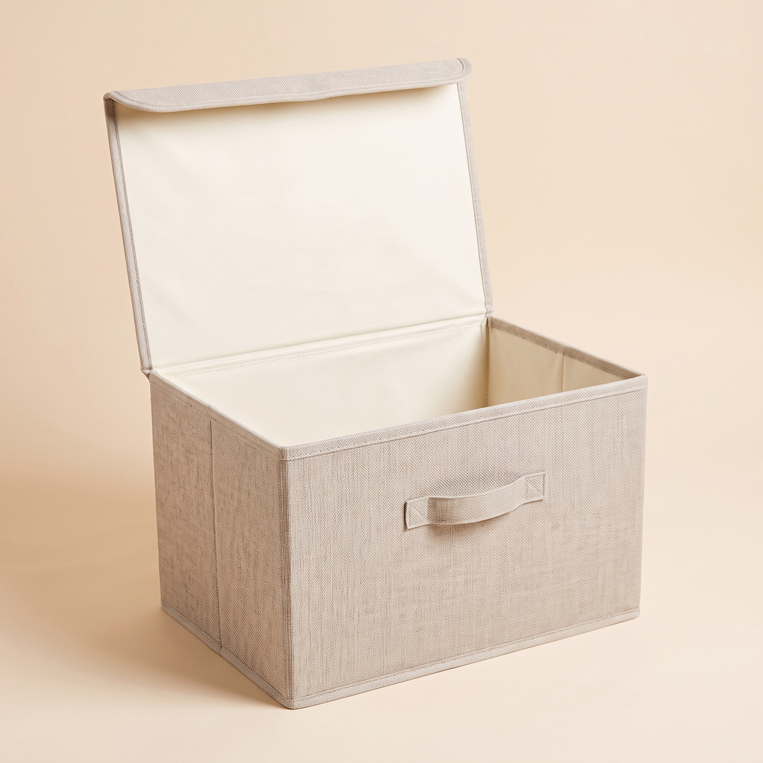 Fabric Storage Bin with Lid – Foldable in Oatmeal – empty with lid propped open, angled view on plain peach background