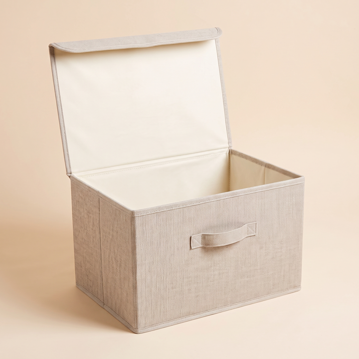 Fabric Storage Bin with Lid – Foldable in Oatmeal – empty with lid propped open, angled view on plain peach background