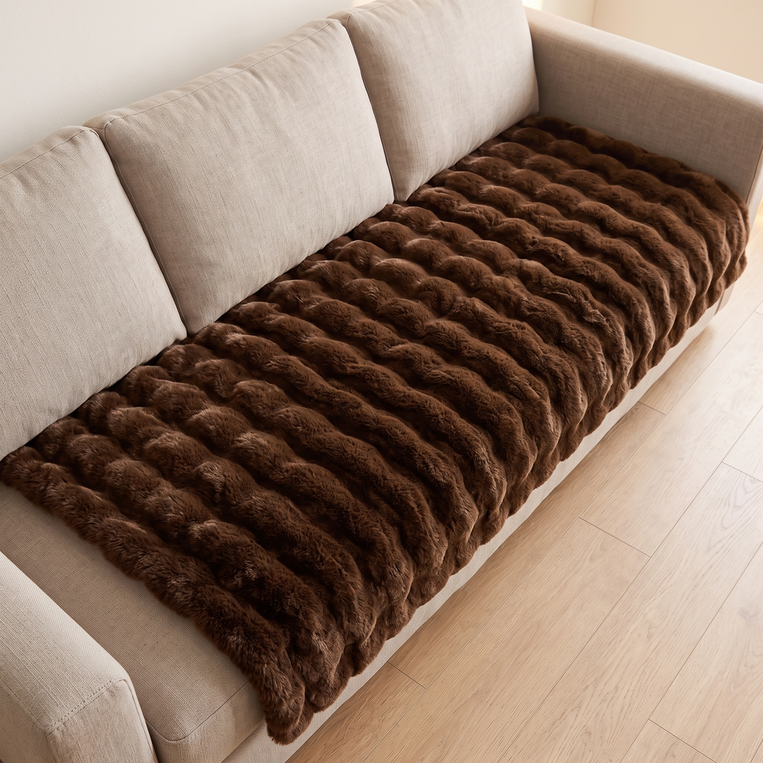 Faux Fur Couch Cover – Plush Bubble Pad in Dark Brown – high-angle view covering a whole sofa beside wood flooring