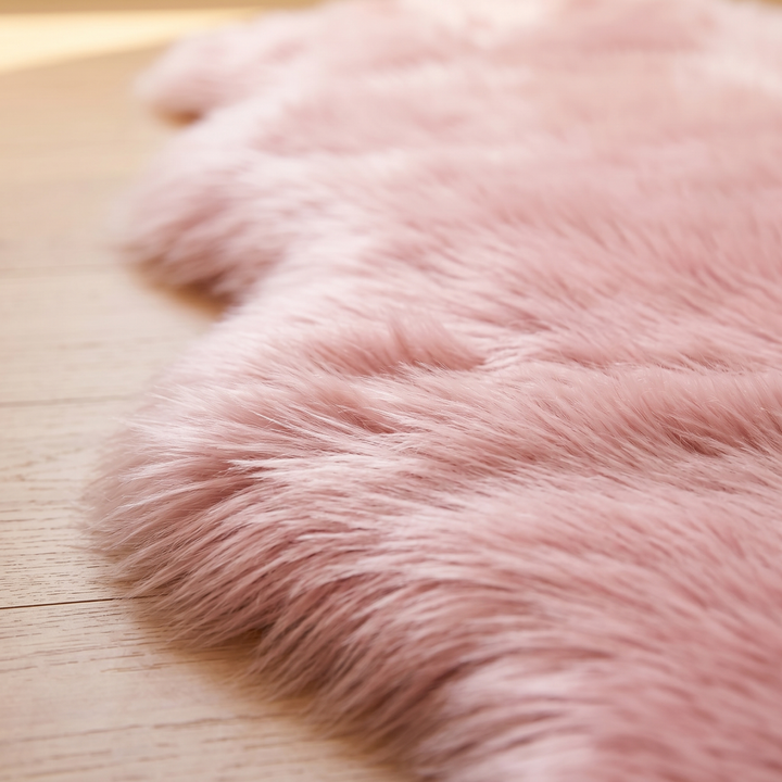 Shaggy Faux Sheepskin Rug in Pink – close-up of the fluffy pile edge on a light wood floor