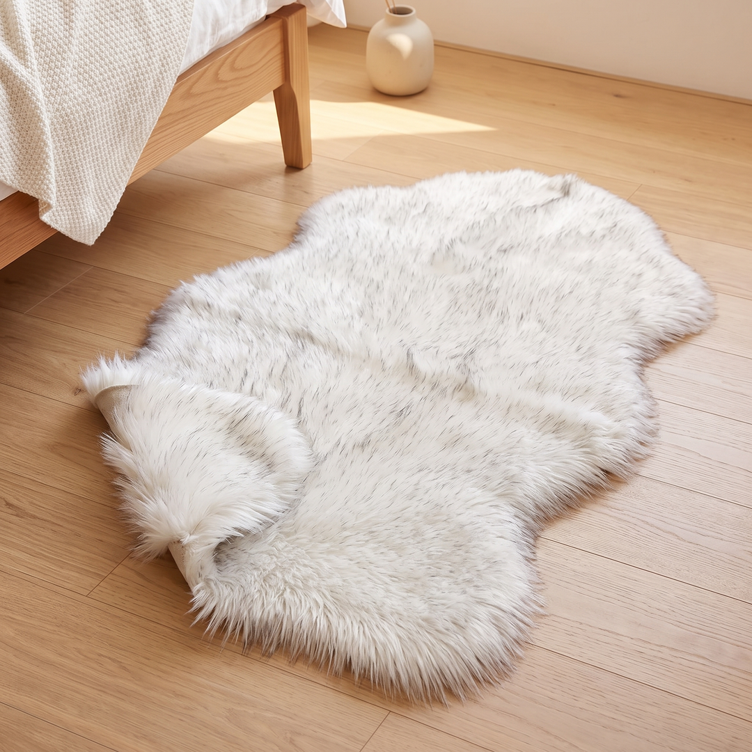 Shaggy Faux Sheepskin Rug in Frosted White – with one end curled over beside a small vase