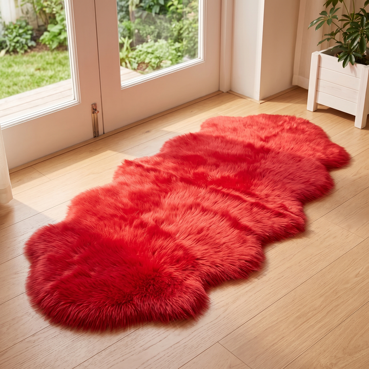 Shaggy Faux Sheepskin Rug in Red – on light wood floor by glass doors overlooking a garden