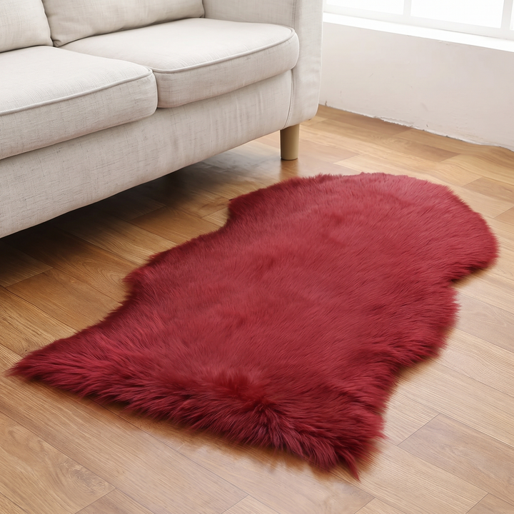 Shaggy Faux Sheepskin Rug in Burgundy – in front of a beige fabric sofa beside a bright window