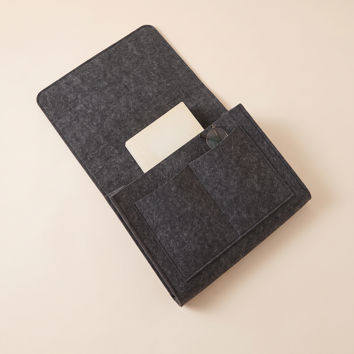 Felt Bedside Caddy – 5 Pockets in Charcoal – laid flat from above on a cream backdrop with a book and glasses