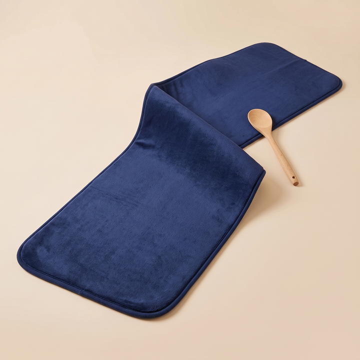 Flannel Kitchen Rug – Cushioned, Non-Slip in Navy Blue – folded over in a loose curve with a wooden spoon beside it