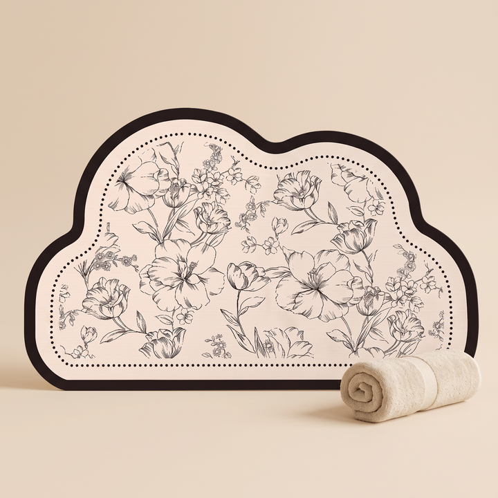 Quick-Dry Bath Mat – Floral, Non-Slip in Cloud – standing upright against beige backdrop beside a rolled cream towel