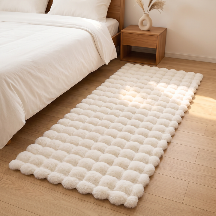 Fluffy Faux Fur Rug – Bubble Texture in White – runner beside a bed on a wood floor in a sunlit bedroom