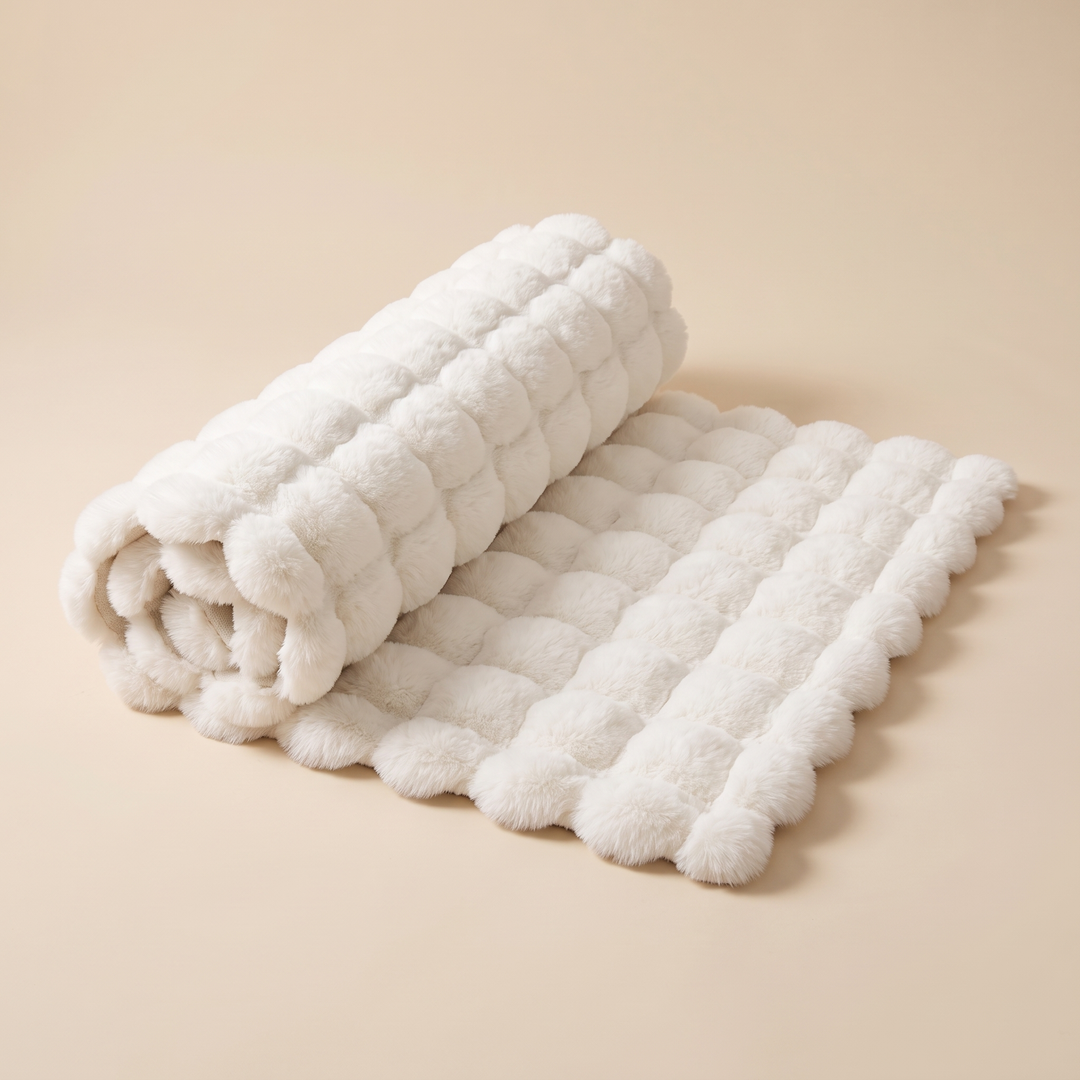Fluffy Faux Fur Rug – Bubble Texture in White – rolled up at one end on a plain beige backdrop