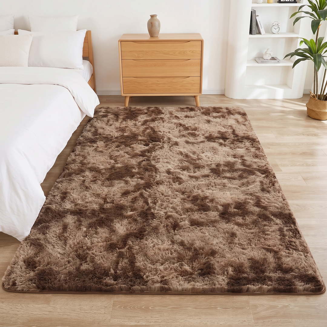Fluffy Shag Rug in Chocolate Brown – Tie-Dye – full rectangular shape beside white bedding and an oak dresser
