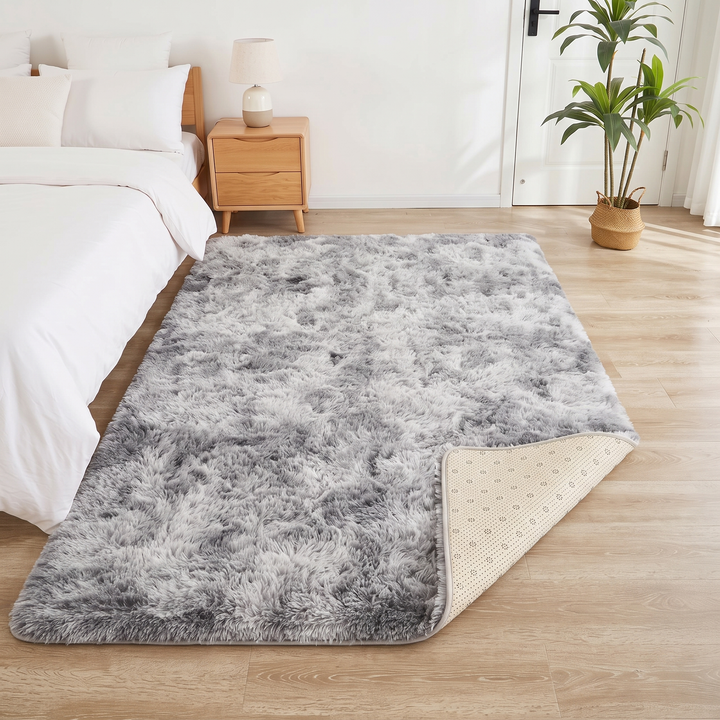 Fluffy Shag Rug in Gray – Tie-Dye – corner turned back, with a table lamp and tall potted plant behind