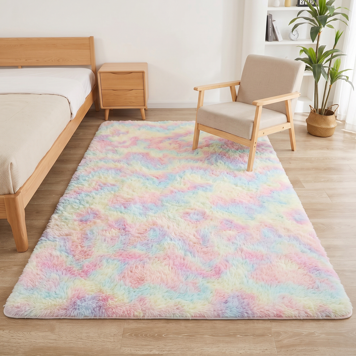 Fluffy Shag Rug in Rainbow – Tie-Dye – far end under a beige cushioned armchair with light wood frame