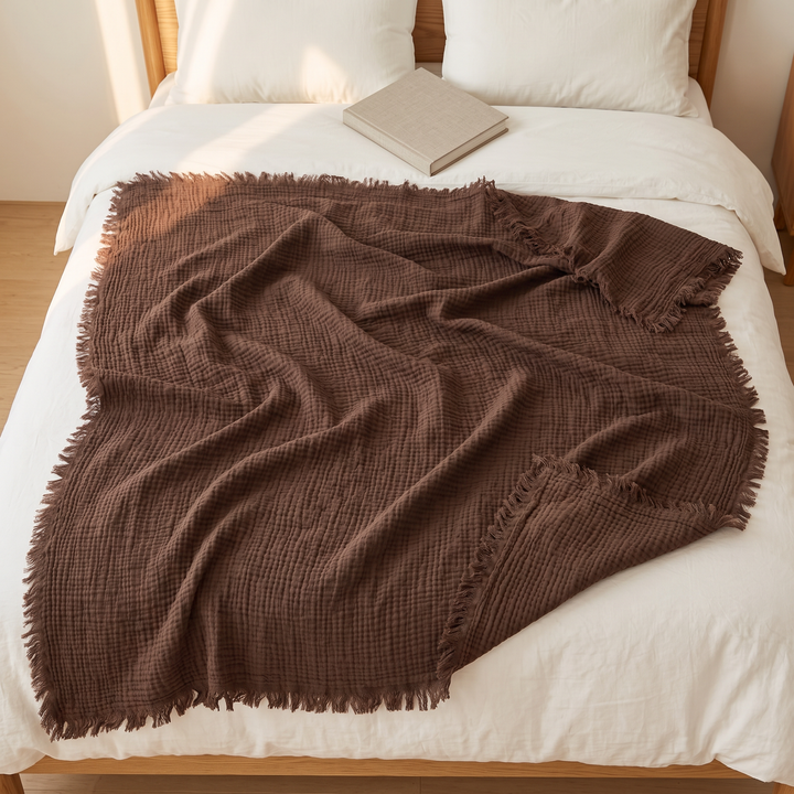 Crinkled Cotton Blanket with Fringe in Chestnut Brown – overhead view spread open on a bed with a book