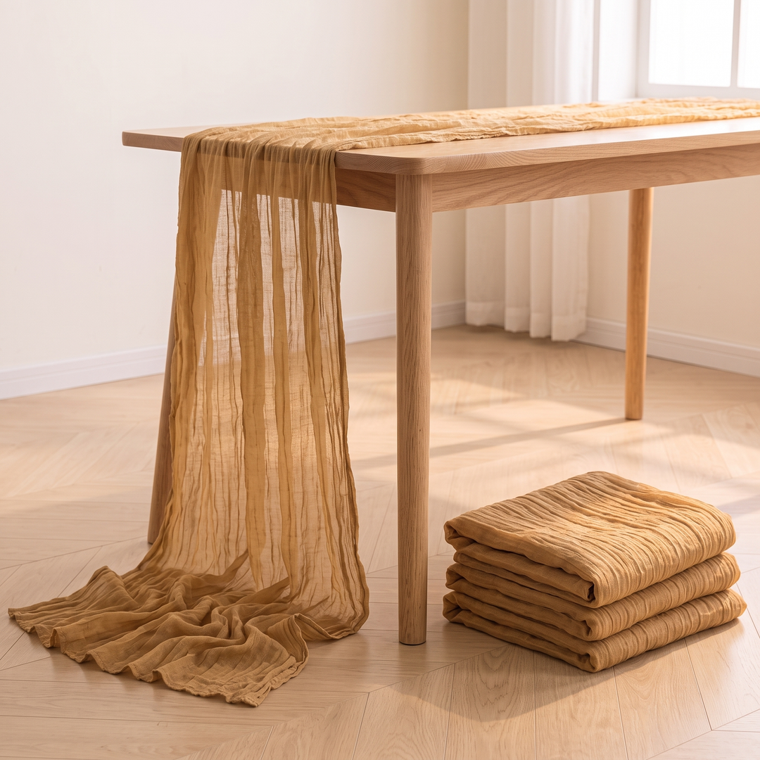 Gauze Table Runners – Set of 4 in Camel – hanging off oak table onto herringbone floor beside folded stack