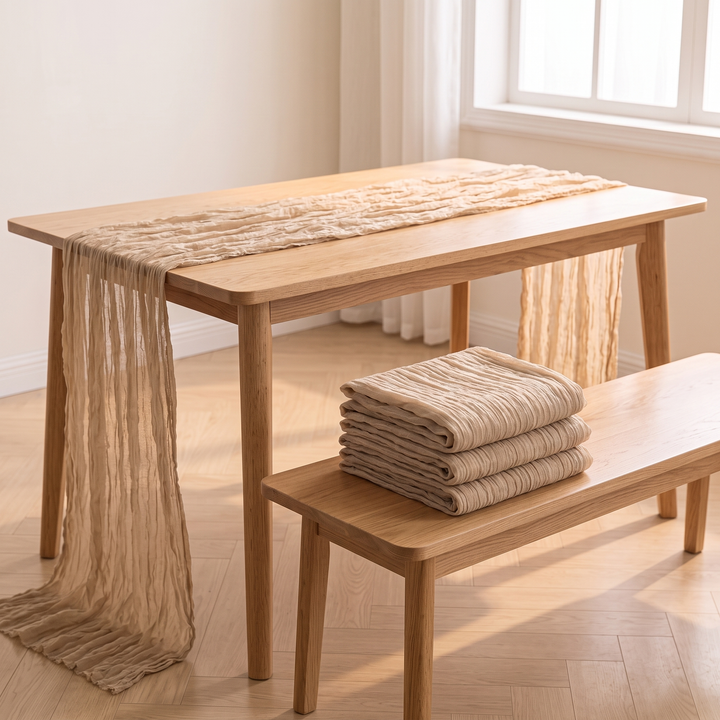 Gauze Table Runners – Set of 4 in Champagne – draped on a table with folded stack on a bench