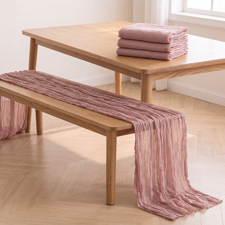 Gauze Table Runners – Set of 4 in Dusty Pink – draped along an oak bench, folded stack on table