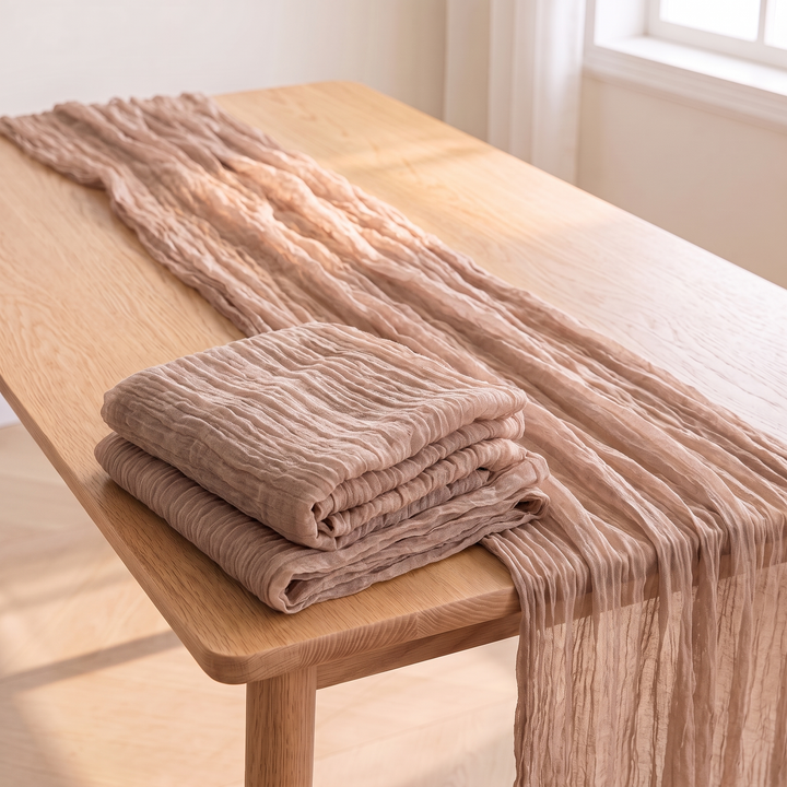Gauze Table Runners – Set of 4 in Taupe – folded stack on oak table corner, sunlit window behind