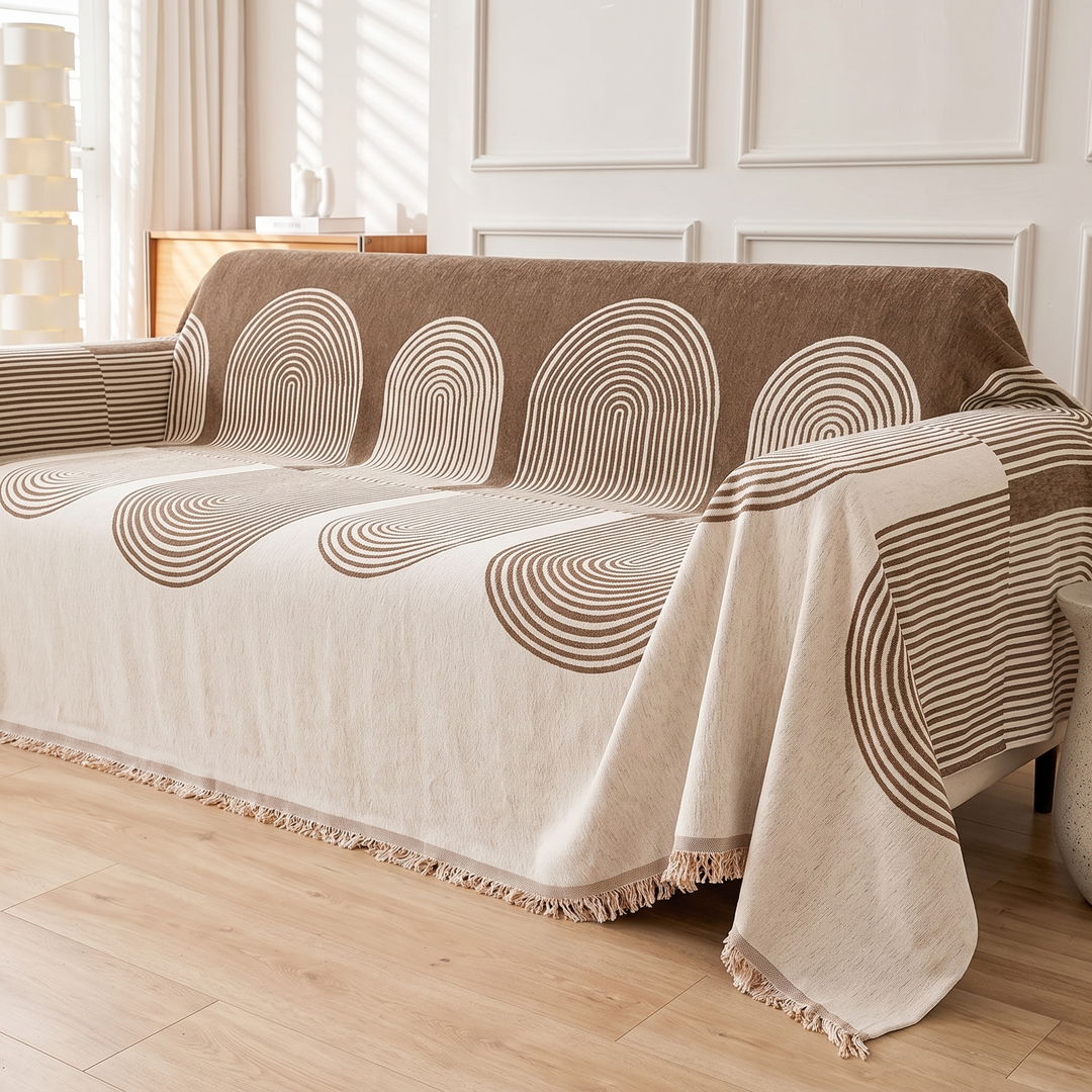 Geometric Chenille Couch Cover with Fringe in Brown – Arch – angled side view of fringed hem hanging over sofa seat