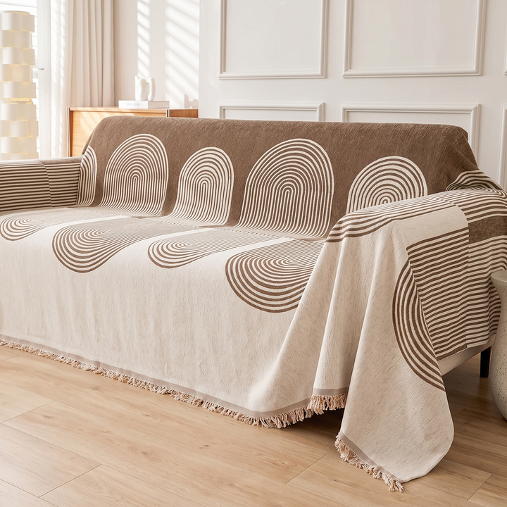 Geometric Chenille Couch Cover with Fringe in Brown – Arch – angled side view of fringed hem hanging over sofa seat