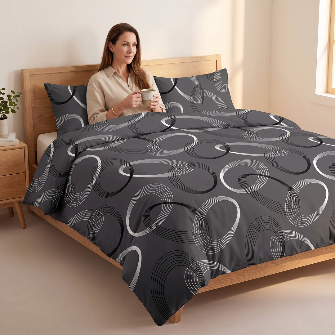 Geometric Duvet Cover Set in Dark Gray Geometric – on a wooden bed with a woman holding a mug