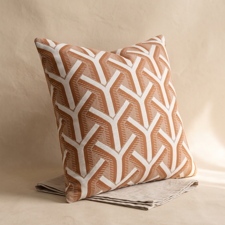 Geometric Throw Pillow Cover – Jacquard in Rust – Arrow – resting on a folded linen cloth