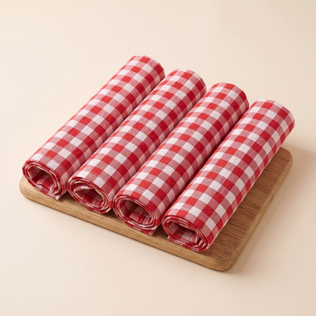 Gingham Cloth Napkins – Set of 4 in Red Gingham – four rolled napkins lined up side by side on a wooden board