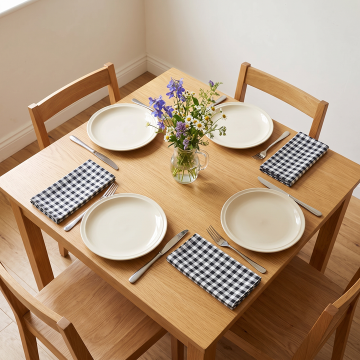 Gingham Cloth Napkins – Set of 4 in Black Gingham – placed beside plates and forks on a square oak dining table