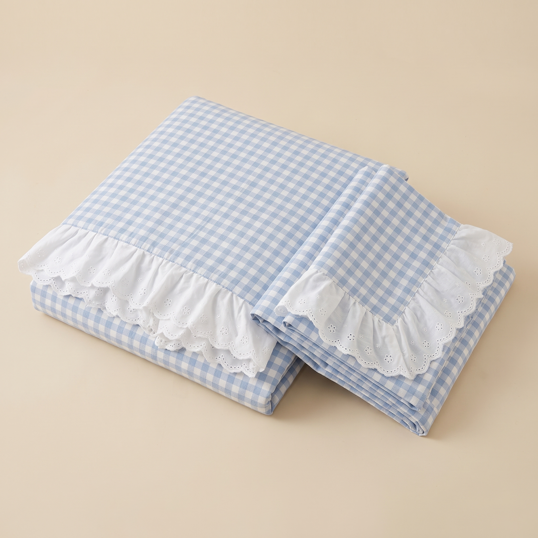 Gingham Duvet Cover Set – Ruffled in Blue Gingham – folded stack with ruffled eyelet edges on a plain beige background