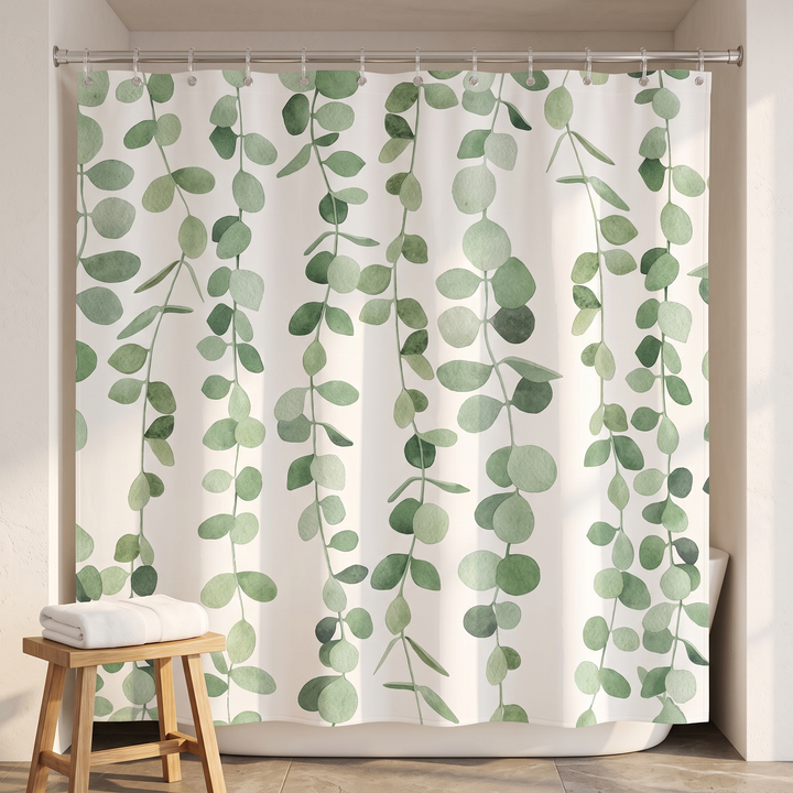 Greenery Shower Curtain – Watercolor Leaves in White – Eucalyptus – beside a wooden stool with a folded white towel