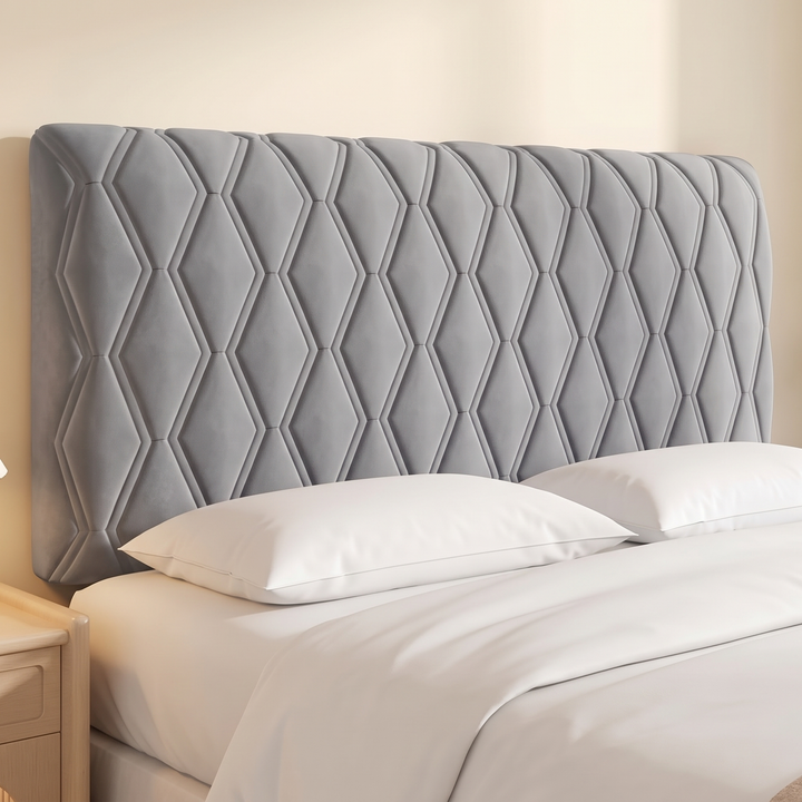 Quilted Headboard Cover – Padded in Gray – fitted on a bed with white pillows beside a wooden nightstand