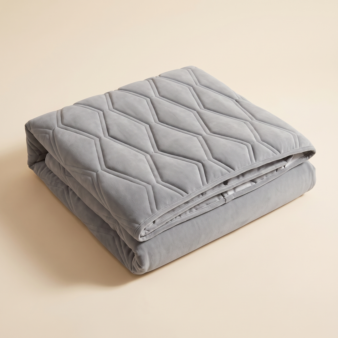 Quilted Headboard Cover – Padded in Gray – folded neatly into a stack against a plain beige background