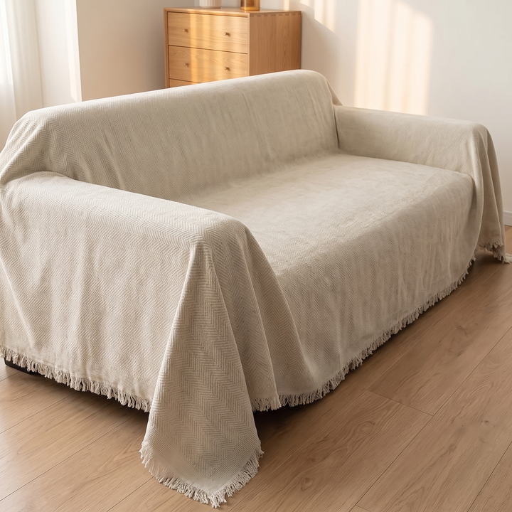 Herringbone Chenille Couch Cover with Fringe in Cream – three-quarter view of fringed hem along the sofa&