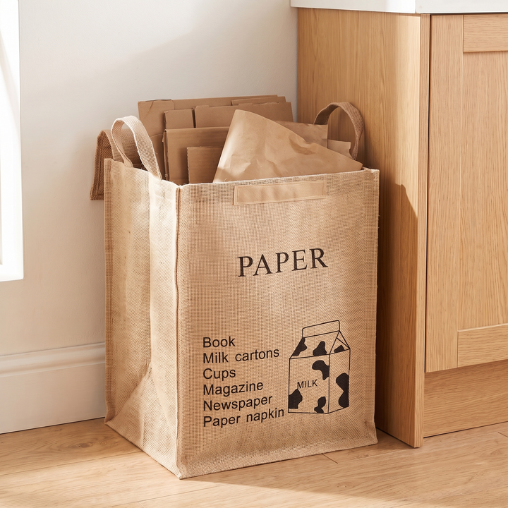 Jute Storage Basket with Lid – Foldable in Natural – Paper Recycling – filled with cardboard and paper beside an oak kitchen cabinet
