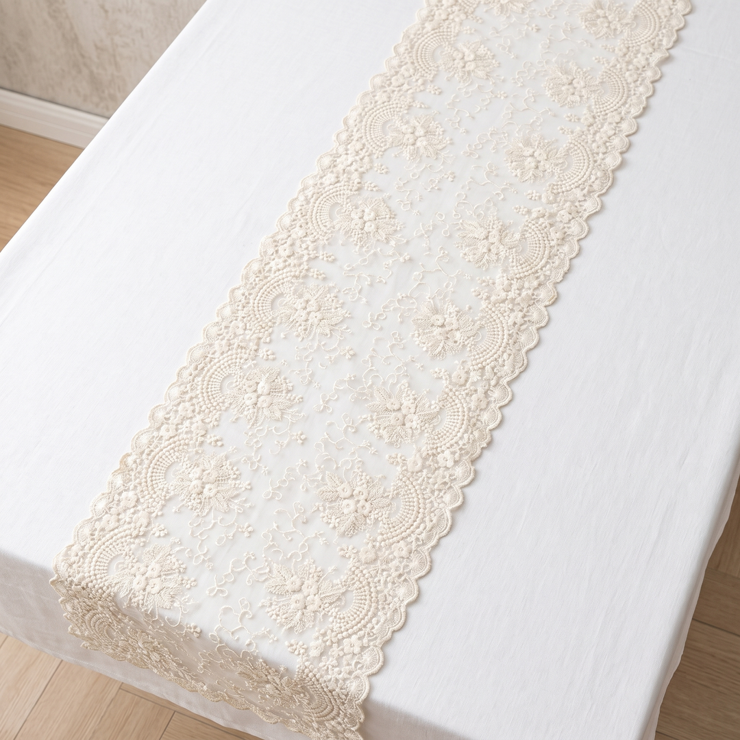 Lace Table Runner in Cream – laid lengthwise on a white tablecloth, viewed from above